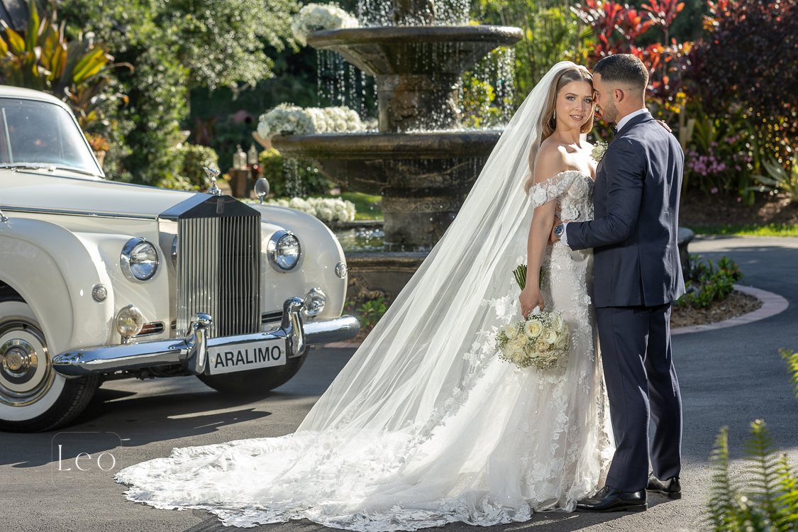 Bride and groom beside a vintage wedding car