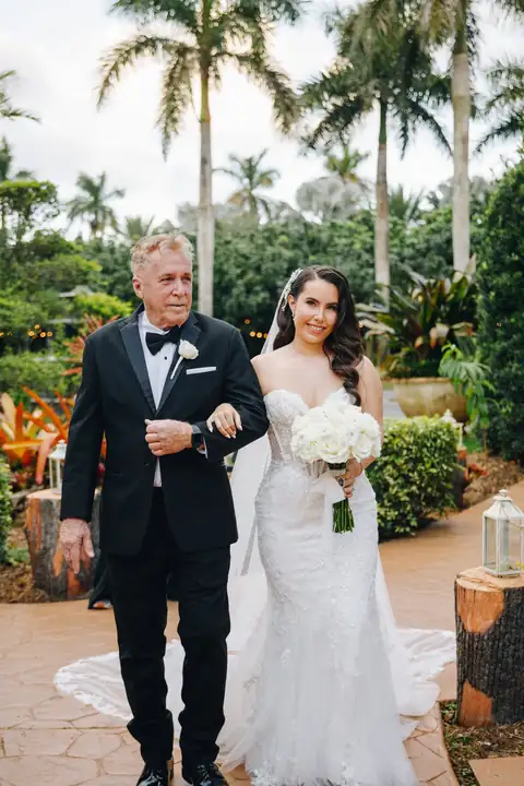 Bride escorted through the garden ceremony space