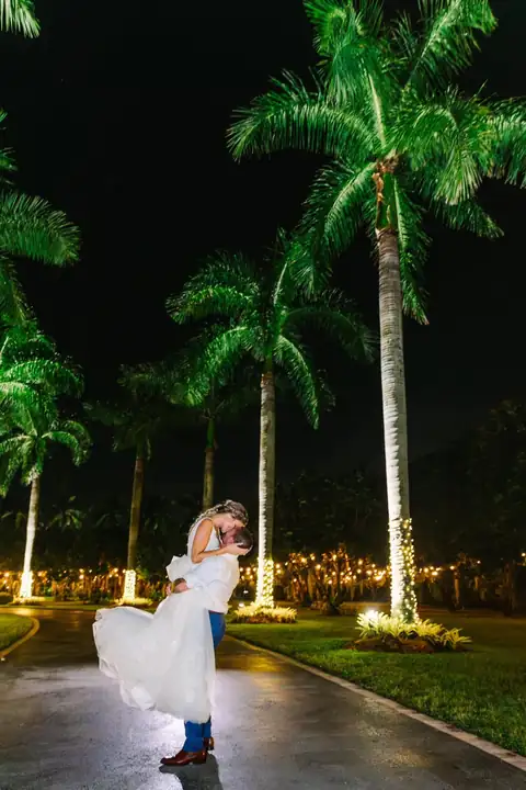 Bride under lit palms at night