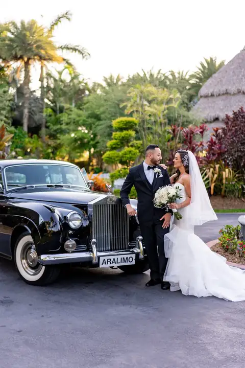 Couple with classic wedding car